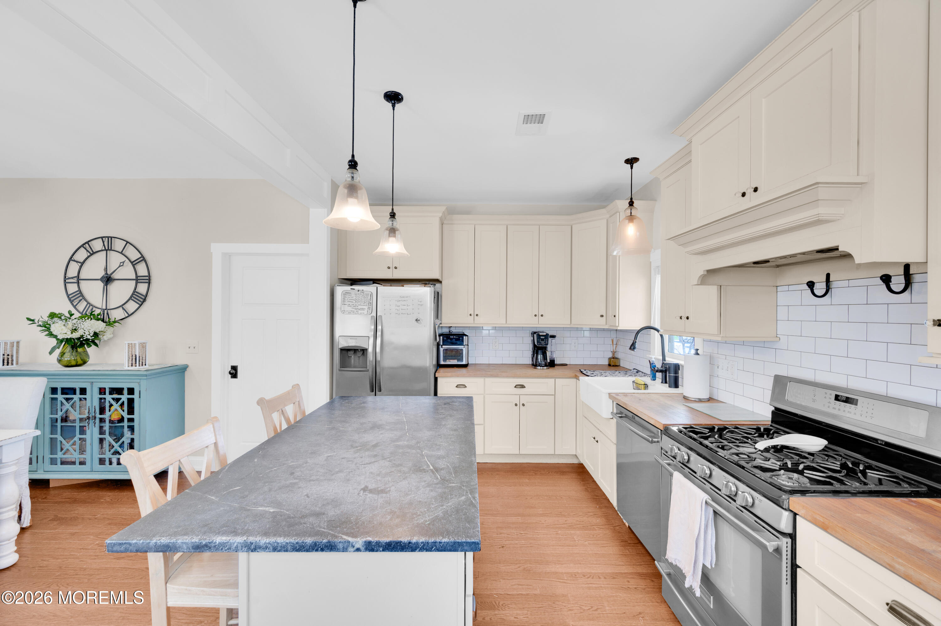203 Riviera Drive Toms River, NJ 08753 - Photo 17 of 37 a kitchen with stainless steel appliances granite countertop a stove a sink dishwasher and white cabinets with wooden floor