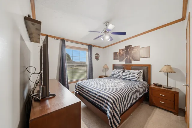 a bedroom with a bed window and a flat screen tv