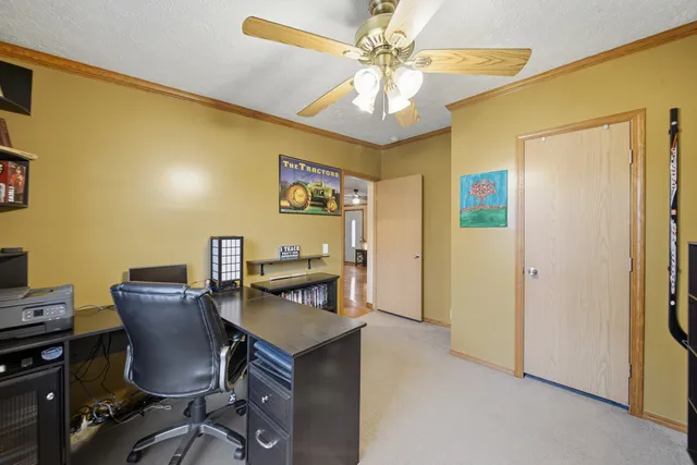 a view of a workspace with furniture and a window