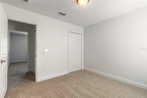 a view of a hallway with closet and bathroom