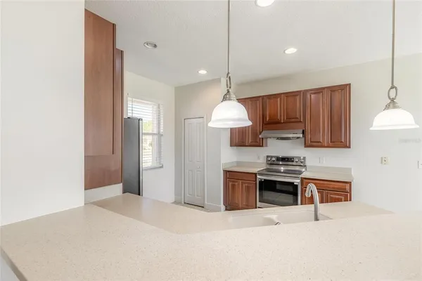 a kitchen with stainless steel appliances kitchen island granite countertop a sink and a refrigerator