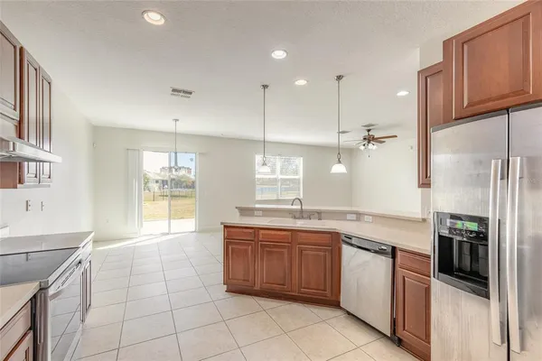 an open kitchen with a sink a refrigerator and a stove top oven