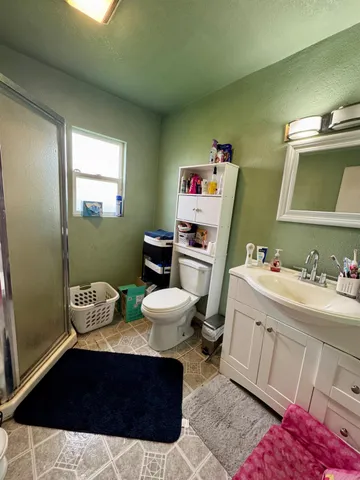 a bathroom with a sink vanity mirror and toilet