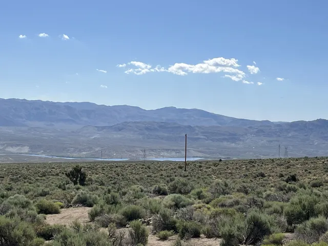 a view of a dry yard with mountains in the background
