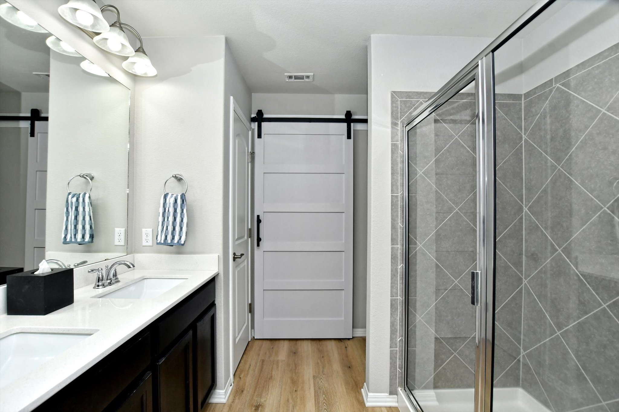 231 Hobby Street Georgetown, TX 78633 - Photo 18 of 29 Dual vanities and a spacious glass-enclosed shower create a practical and refreshing bathroom.