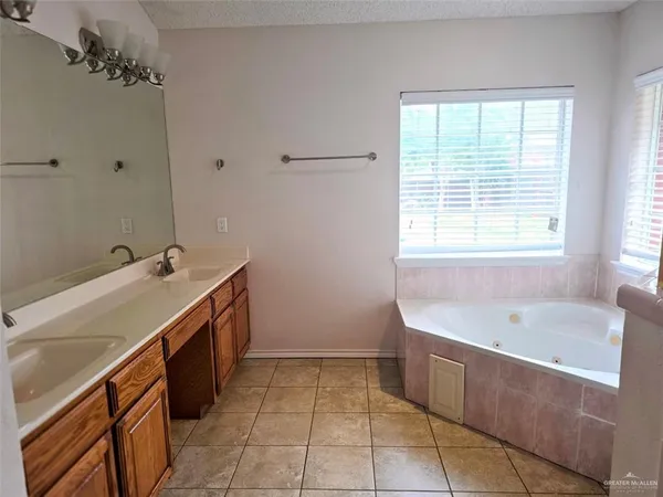 a spacious bathroom with a tub sink and mirror