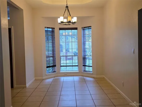 a view of a hallway with windows and chandelier
