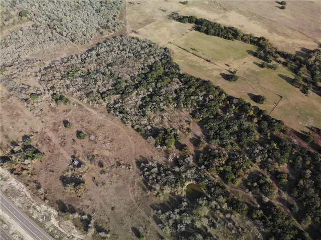 a view of a dry yard with wooden fence