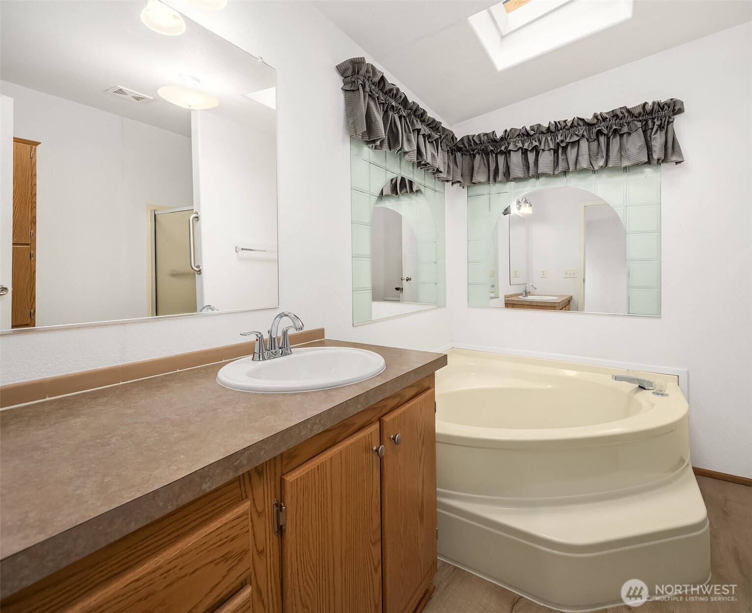 3222 206th Place Southeast Bothell, WA 98012 - Photo 14 of 32 a bathroom with a sink a mirror and a bathtub
