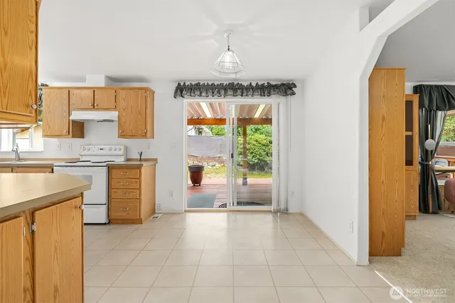 a open kitchen with white cabinets and white appliances