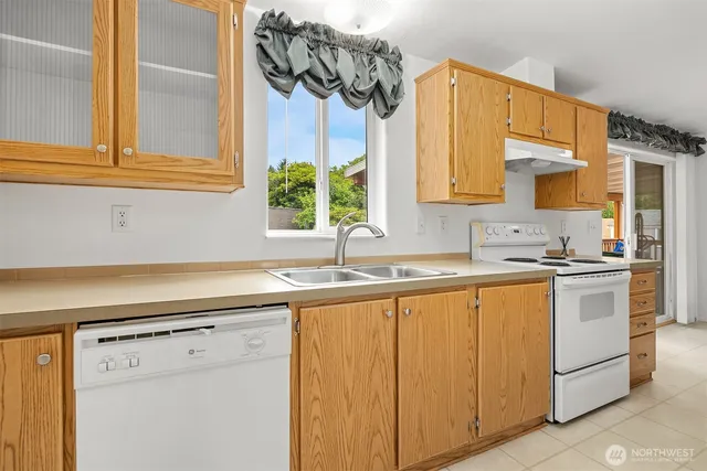 a kitchen with stainless steel appliances granite countertop a sink and a white cabinets