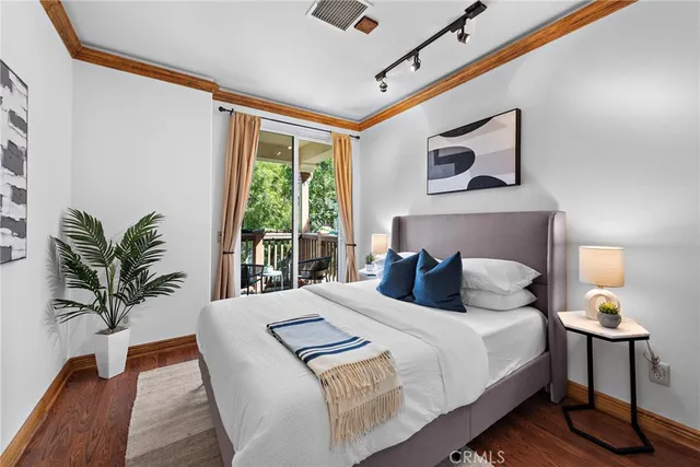 a bedroom with a large bed and a potted plant