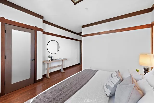 a bedroom with a bed and wooden floor