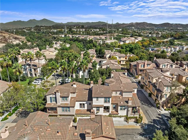 an aerial view of residential houses with outdoor space and trees