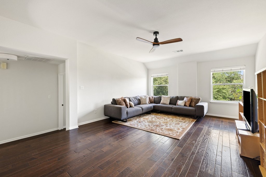 6704 Kiev Cove Austin, TX 78739 - Photo 22 of 37 Hardwood floors and generous windows elevate this comfortable family room.