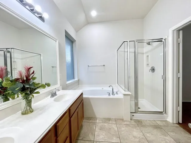 a bathroom with a tub a sink and a mirror