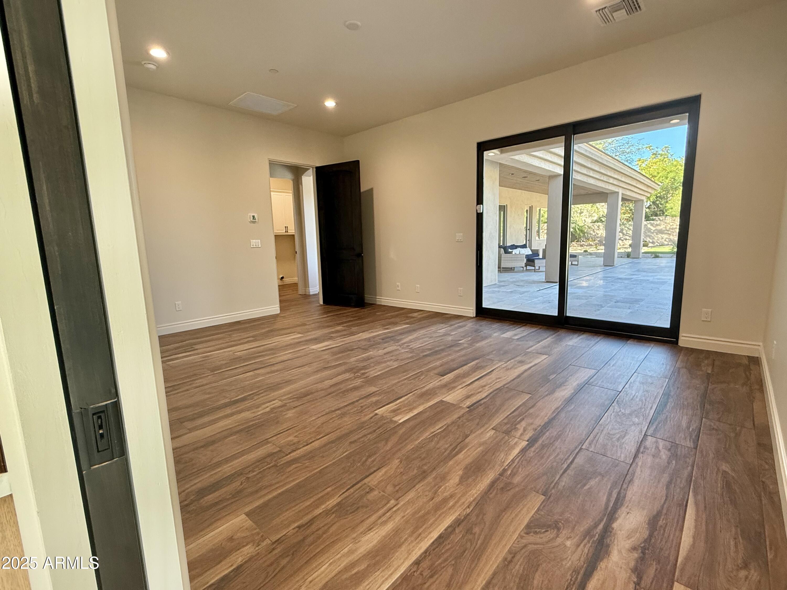 27227 North Miller Road Scottsdale, AZ 85266 - Photo 11 of 31 a view of an empty room with wooden floor and a window