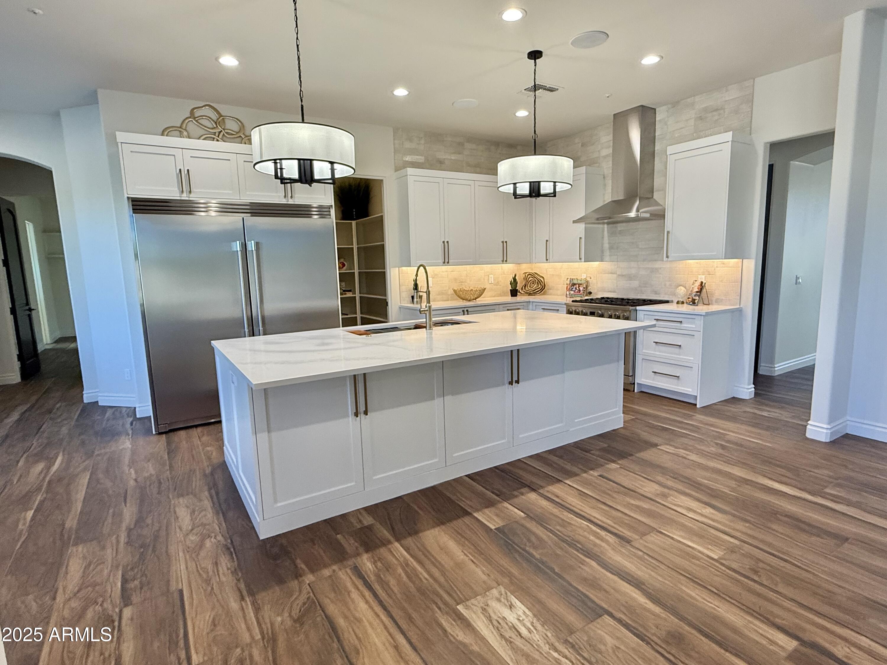 27227 North Miller Road Scottsdale, AZ 85266 - Photo 7 of 31 a large kitchen with stainless steel appliances a large counter top a sink refrigerator and a fireplace