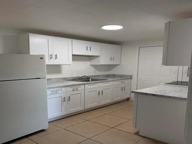 a kitchen with granite countertop cabinets sink and white appliances