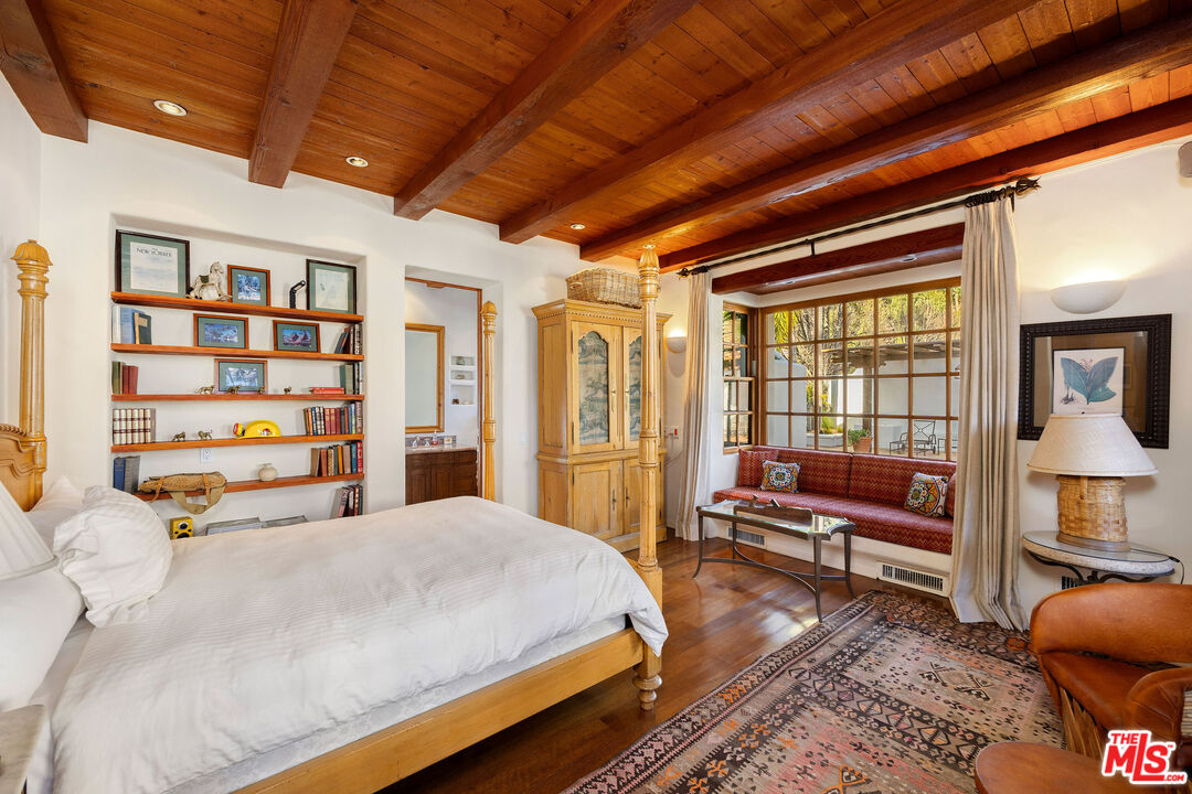 25127 Jim Bridger Road Hidden Hills, CA 91302 - Photo 29 of 50 a spacious bedroom with a bed and a book shelf
