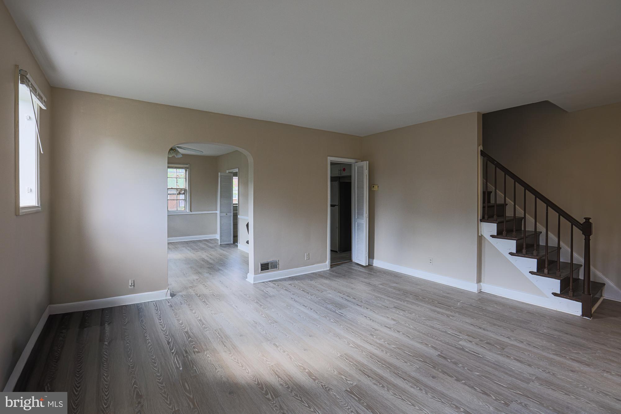 3914 Bancroft Road Baltimore, MD 21215 - Photo 4 of 25 a view of an empty room with wooden floor and stairs