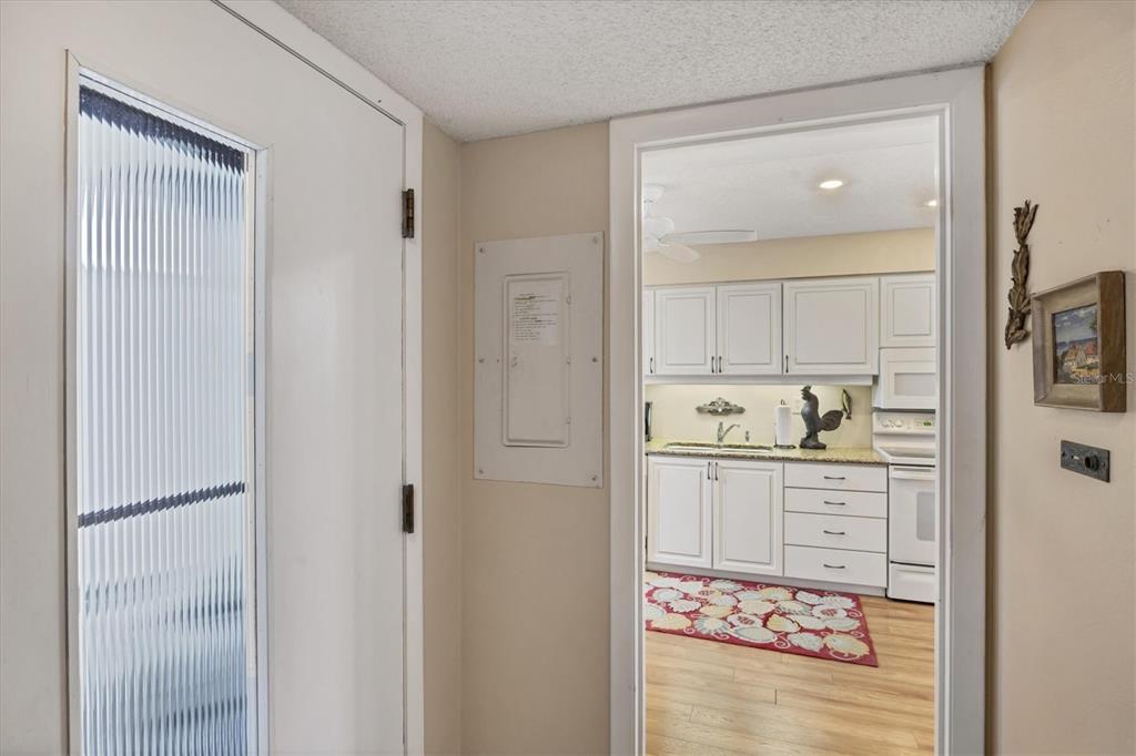 825 Bayport Way, Unit 825 Longboat Key, FL 34228 - Photo 20 of 62 a hallway with cabinets and wooden floor