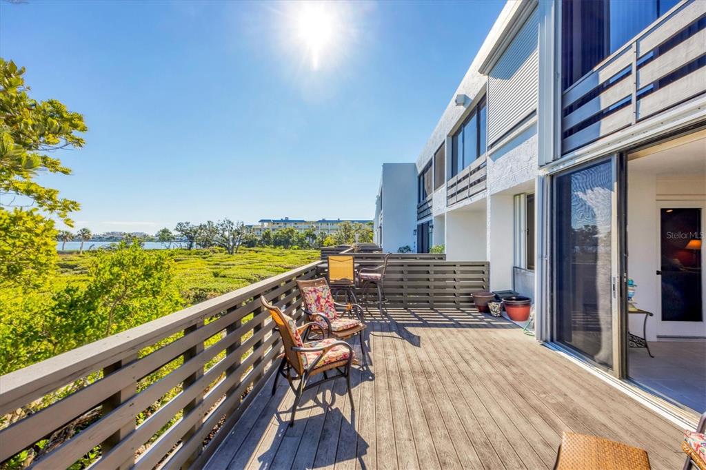 825 Bayport Way, Unit 825 Longboat Key, FL 34228 - Photo 51 of 62 a view of a balcony with wooden floor and outdoor space