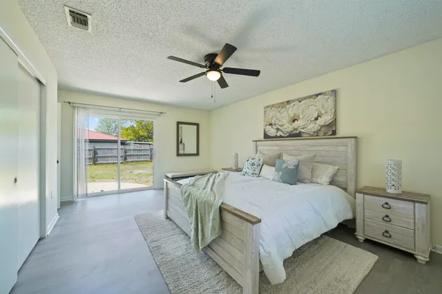 a bedroom with a large bed and a chandelier