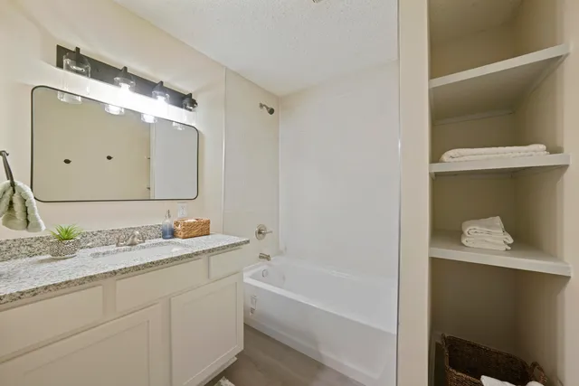 a bathroom with a tub sink and mirror