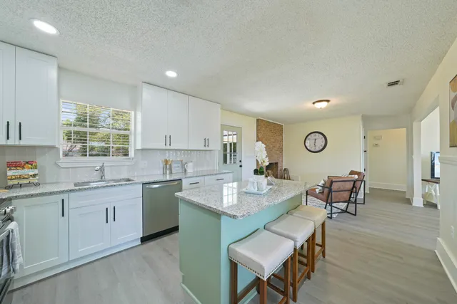 a open kitchen with sink cabinets dining table and chairs