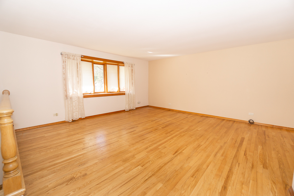 1908 Capri Lane Schaumburg, IL 60193 - Photo 5 of 39 an empty room with wooden floor and windows