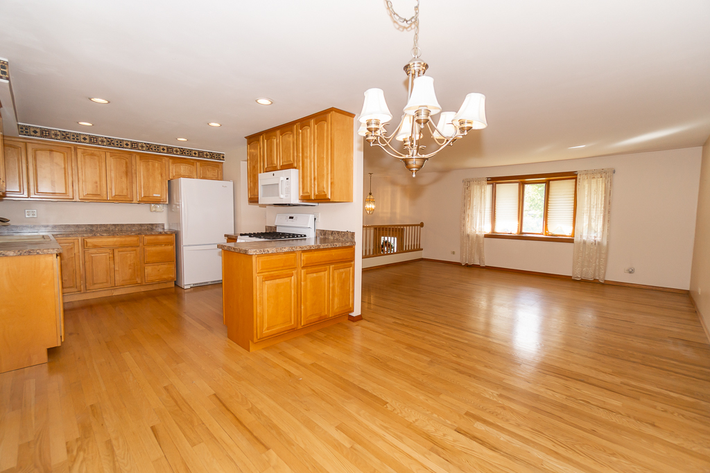 1908 Capri Lane Schaumburg, IL 60193 - Photo 9 of 39 a view of a kitchen with kitchen island a sink wooden floor and a view of living room
