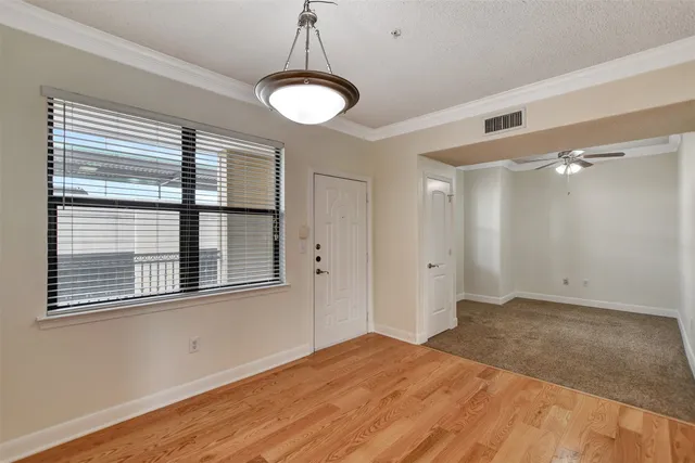 a view of empty room with window and ceiling fan