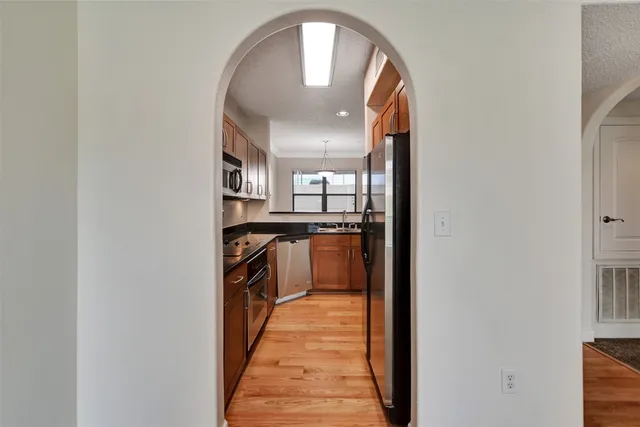 a kitchen with stainless steel appliances granite countertop a sink a stove and cabinets