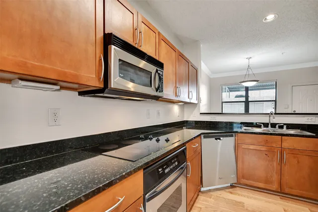 a kitchen with a sink a refrigerator and cabinets