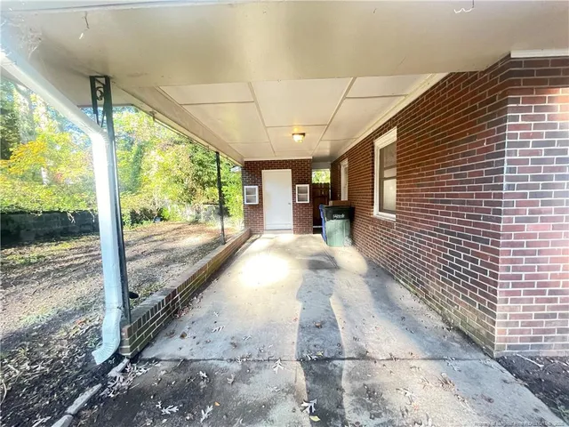 a view of a porch with a floor to ceiling window next to a yard