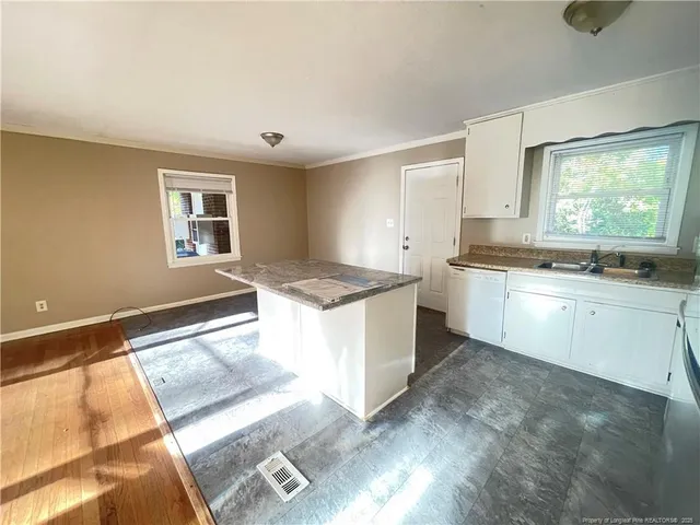 a large white kitchen with a sink and cabinets