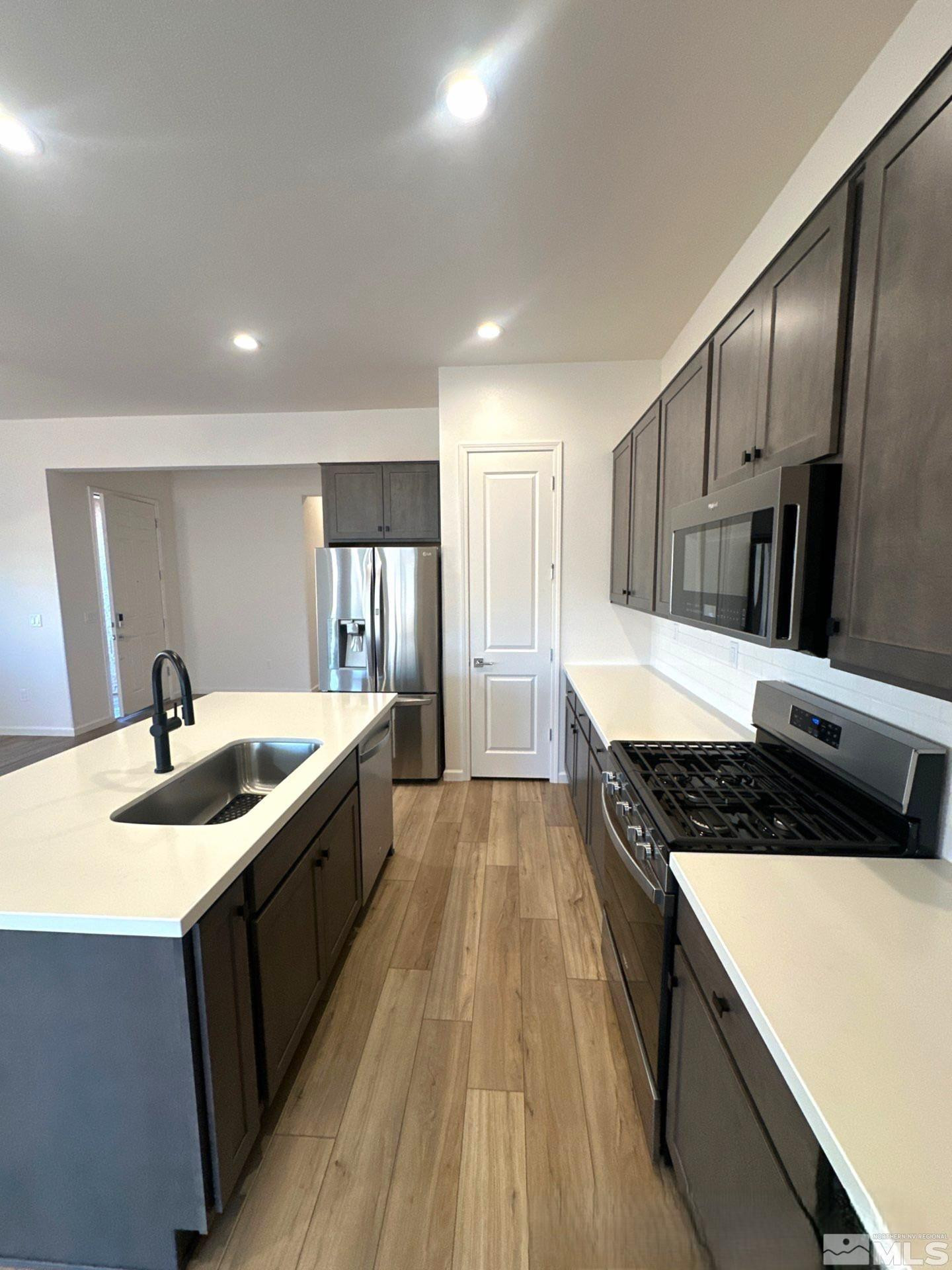2494 Metolius Drive Sparks, NV 89436 - Photo 5 of 22 a kitchen with stainless steel appliances granite countertop a sink a stove and a refrigerator