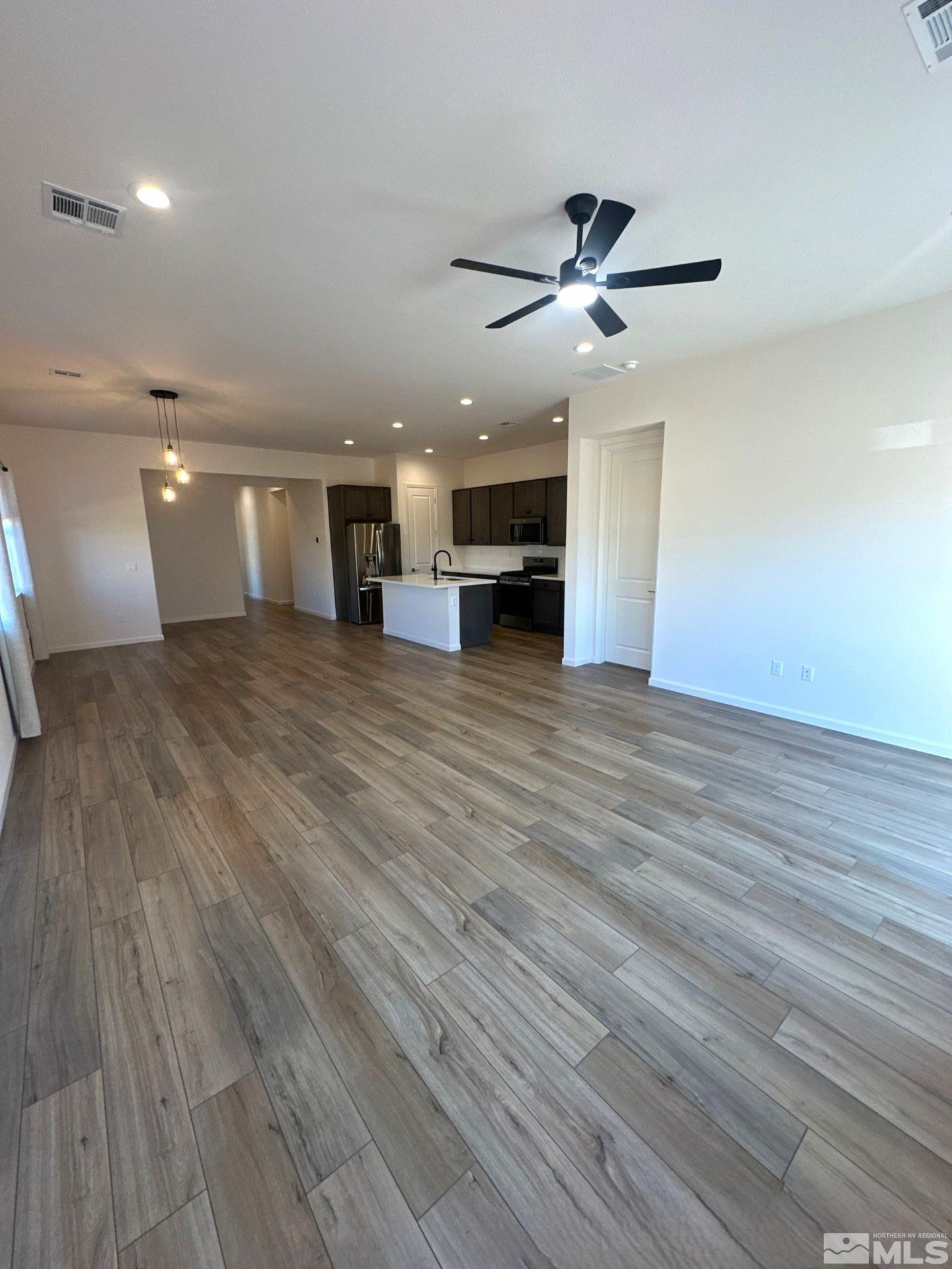 2494 Metolius Drive Sparks, NV 89436 - Photo 8 of 22 an empty room with wooden floor ceiling fan and windows