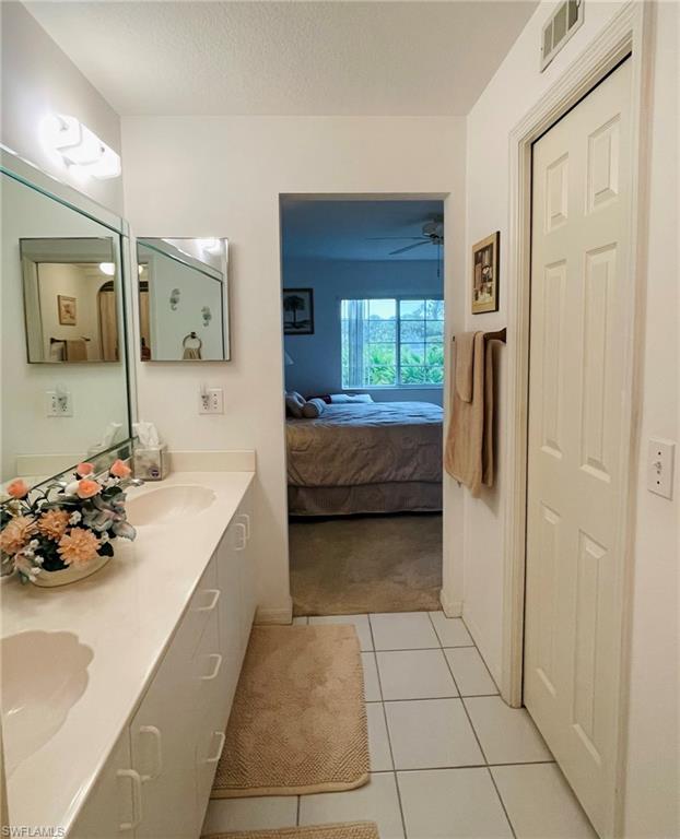 153 Gabriel Circle, Unit 3003 Naples, FL 34104 - Photo 13 of 38 a en suite bathroom with a tub sink and mirror