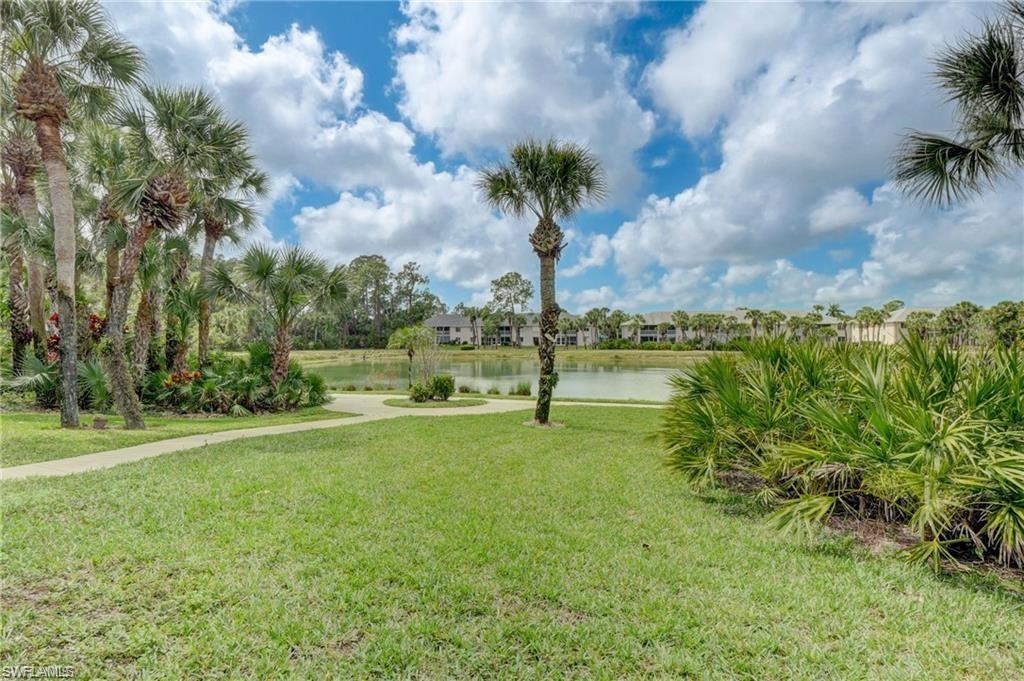 153 Gabriel Circle, Unit 3003 Naples, FL 34104 - Photo 26 of 38 a view of a golf course with a lake