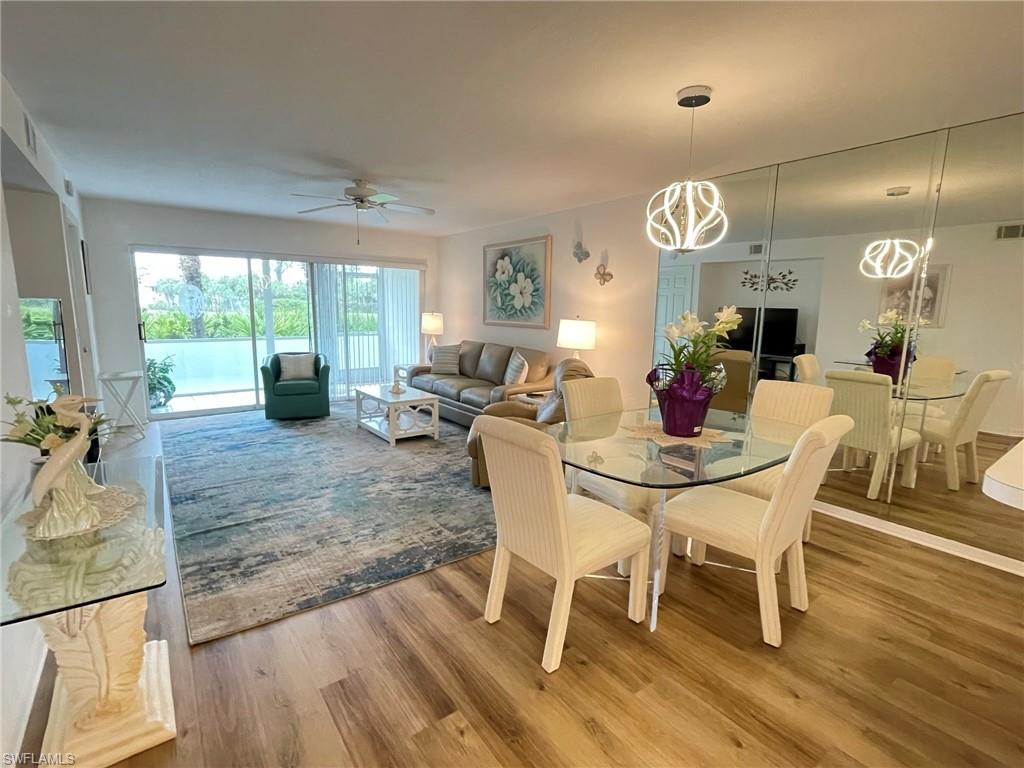 153 Gabriel Circle, Unit 3003 Naples, FL 34104 - Photo 7 of 38 a view of a dining room with furniture wooden floor and chandelier