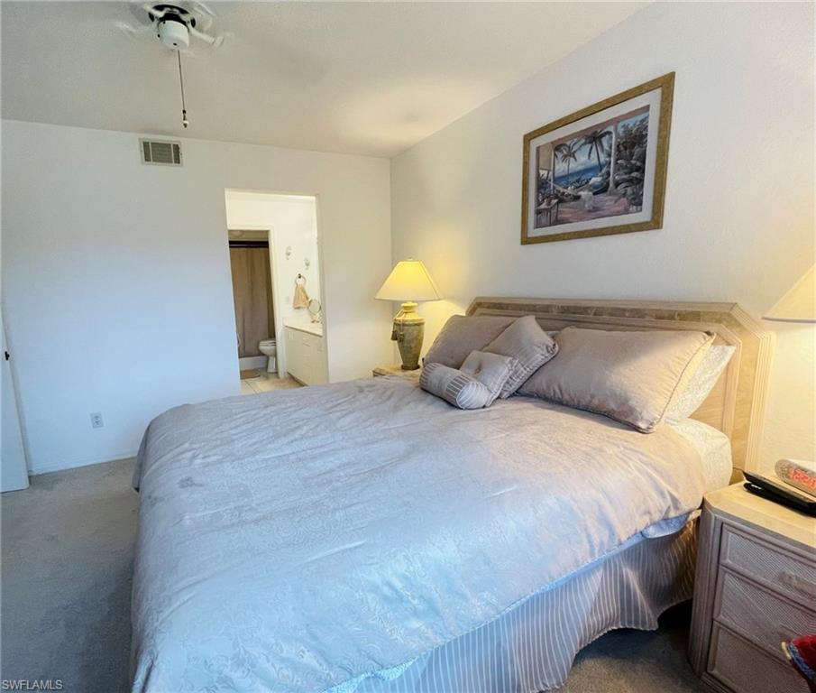 153 Gabriel Circle, Unit 3003 Naples, FL 34104 - Photo 9 of 38 a bedroom with a bed and a painting on the wall
