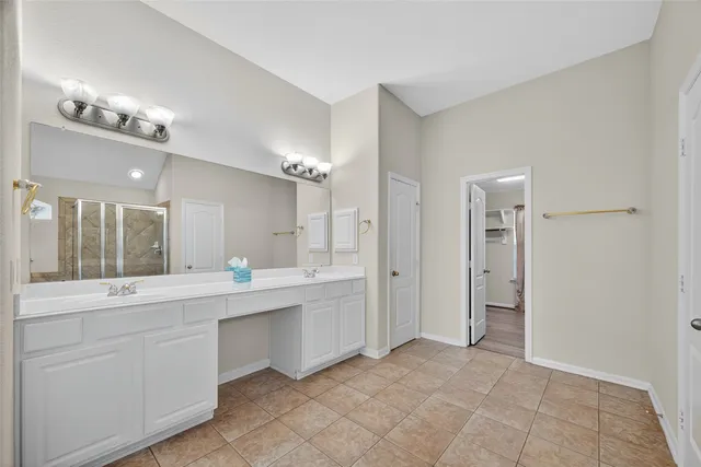 a bathroom with a double vanity sink a mirror and a bathtub