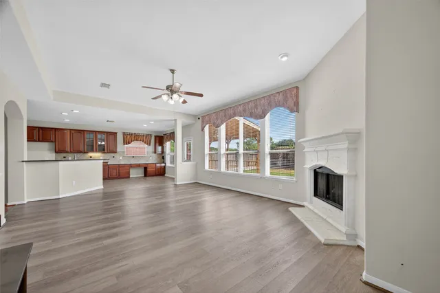 a view of a livingroom with fireplace wooden floor and windows