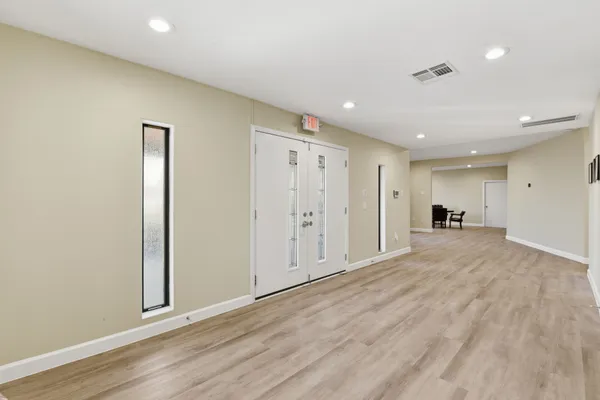 a view of an empty room with wooden floor