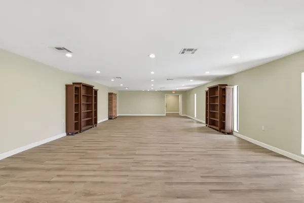 a view of an empty room with wooden floor and closet
