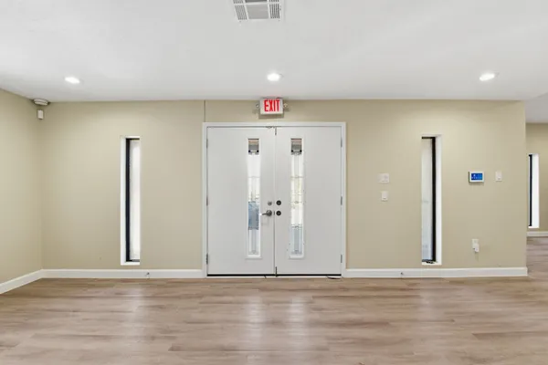 a view of an empty room with wooden floor
