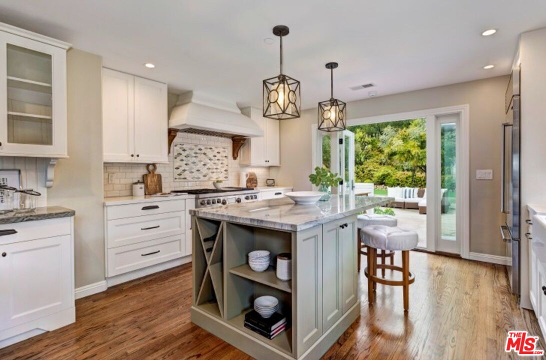 20779 Big Rock Drive Malibu, CA 90265 - Photo 12 of 37 a kitchen with stainless steel appliances granite countertop a stove a refrigerator a kitchen island a stove and a wooden floors