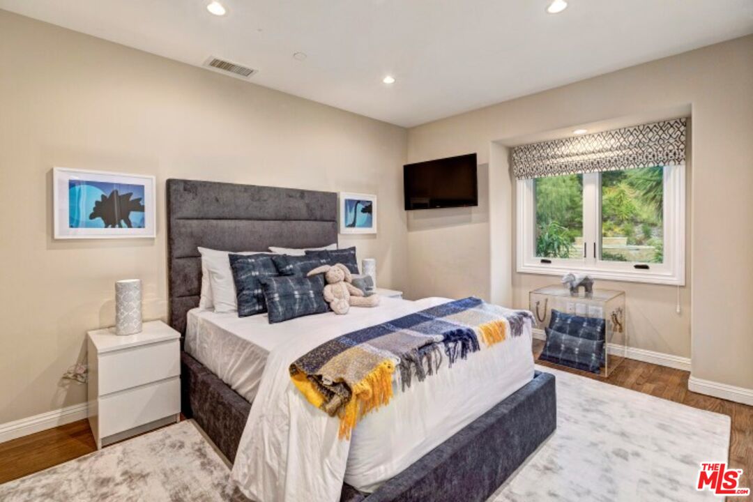 20779 Big Rock Drive Malibu, CA 90265 - Photo 22 of 37 a bedroom with a large bed and a flat screen tv